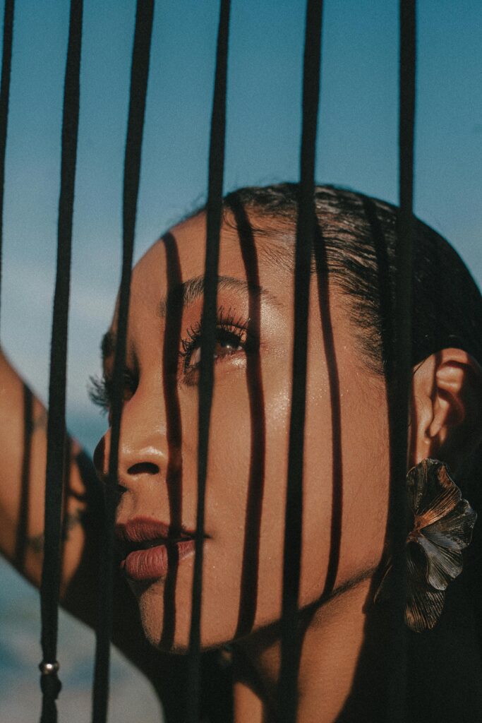 Портрет в тенях и солнечном свете(A close-up portrait capturing the play of light and shadow across the woman’s face, creating a dramatic and intimate visual rhythm)